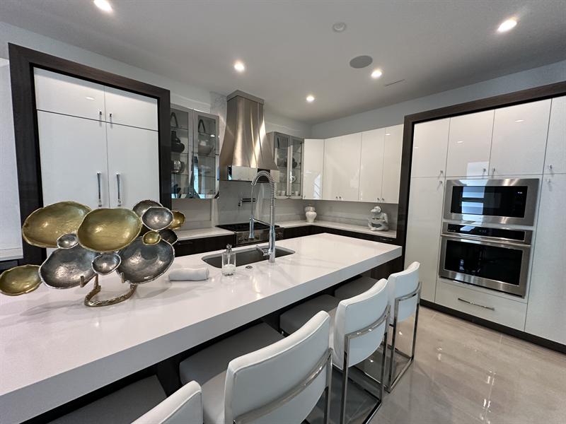 Modern white high-gloss kitchen cabinets with a large island