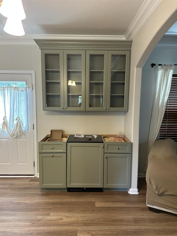 Sage green built-in hutch with glass-front upper cabinets