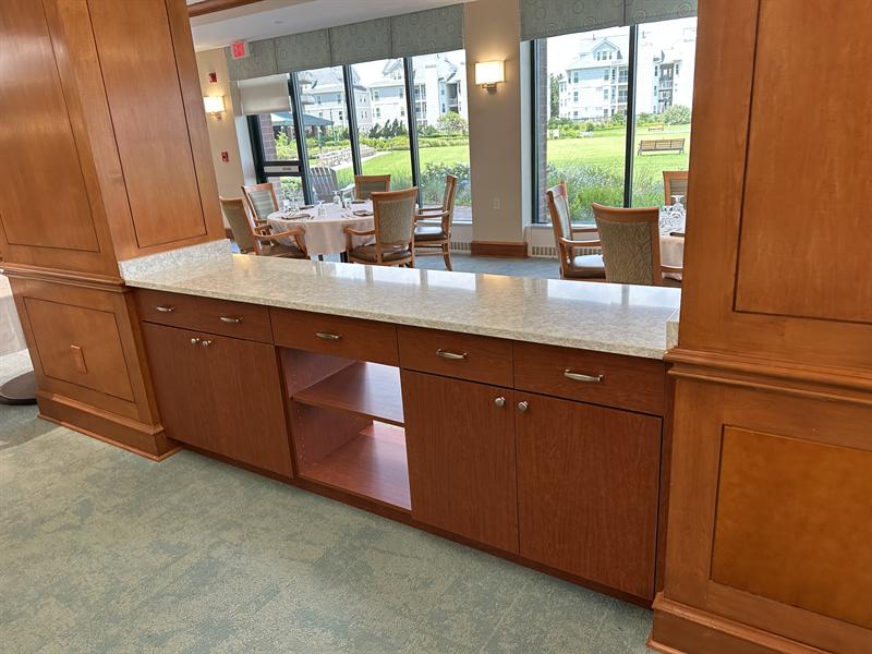 Commercial cherry wood cabinetry and serving counter in a community dining room